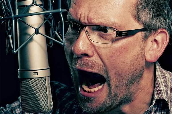 Male German voice-over talent shouts into microphone.