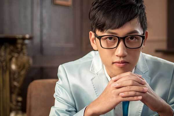 Young Chinese Male Voice Talent clasps hands.