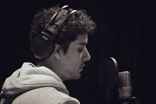 Male Argentinean voice talent in dark room with headphones on.
